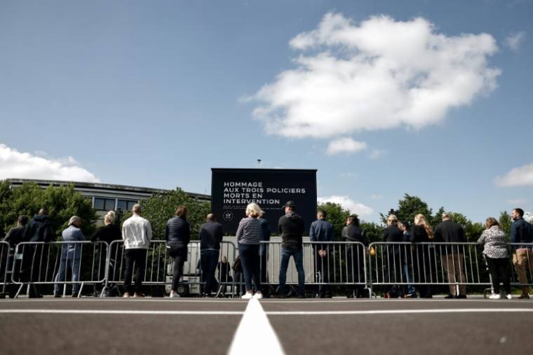 Des badauds attendent devant la nouvelle école de police de Roubaix pour assister à la cérémonie d'hommage aux trois policiers tués dans une collision avec un véhicule roulant à contre-sens, le 25 mai 2023 ( AFP / Sameer Al-Doumy )