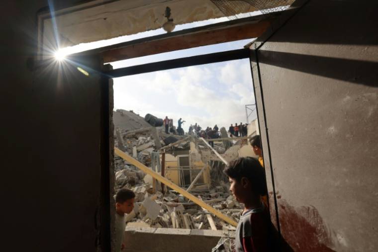 Des Palestiniens inspectent les ruines d'un immeuble touché par un raid israélien, le 21 avril 2024 ( AFP / MOHAMMED ABED )