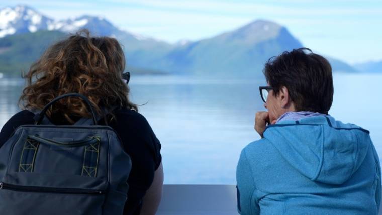 Des touristes admirent le paysage à bord d'u ferry à Margerholm, en Norvège, le 27 juin 2024 ( AFP / Olivier FENIET )