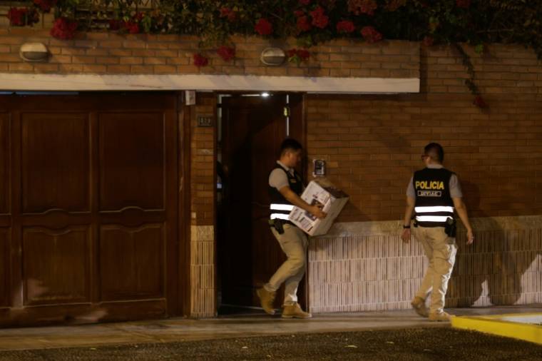 Des policiers quittent le domicile de la présidente péruvienne Dina Boluarte lors d'une perquisition ordonnée par le ministère public le 30 mars 2024 à Lima ( AFP / Juan Carlos CISNEROS )