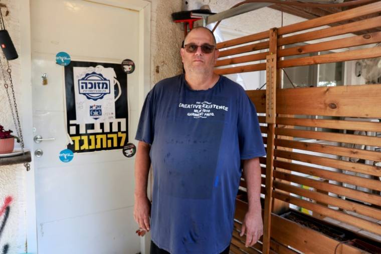 Shar Shnurman, premier survivant de l'attaque du Hamas le 7 octobre à être revenu habiter le kibboutz israélien de Kfar Aza, devant sa maison, le 16 avril 2024 ( AFP / Menahem Kahana )