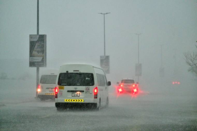 Des véhicules circulent sur une route inondée lors de fortes pluies à Dubaï, le 16 avril 2024 ( AFP / Giuseppe CACACE )