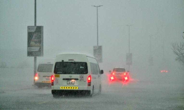 Des véhicules circulent sur une route inondée lors de fortes pluies à Dubaï, le 16 avril 2024 ( AFP / Giuseppe CACACE )