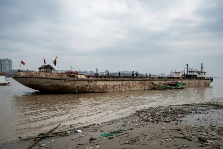Des ouvriers récupérent un navire coulé dans le fleuve Yangon, le 27 janvier 2024 à Rangoun, en Birmanie ( AFP / Sai Aung MAIN )