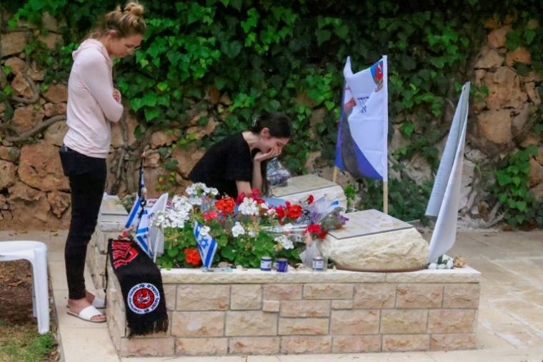 Des Israéliens se rendent au cimetière militaire du Mont Herzl à Jérusalem le 12 mai 2024, à la veille du Jour du Souvenir pour les soldats tombés au combat ( AFP / Menahem KAHANA )