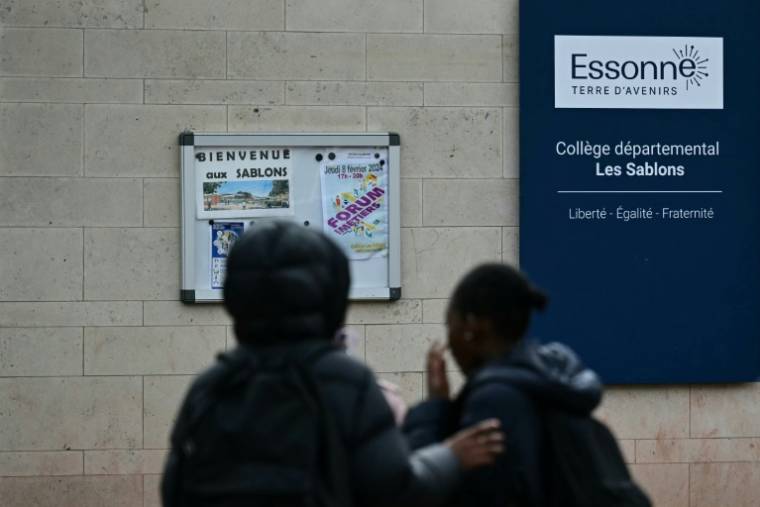 Des élèves devant l'entrée du collège Les Sablons à Viry-Châtillon, en Essonne, où était scolarisé un adolescent passé à tabac, qui a succombé à ses blessures le 5 avril 2024 ( AFP / Miguel MEDINA )