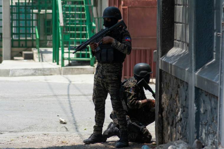 Des policiers en position dans une rue de Port-au-Prince, le 8 avril 2024 en Haïti ( AFP / Clarens SIFFROY )