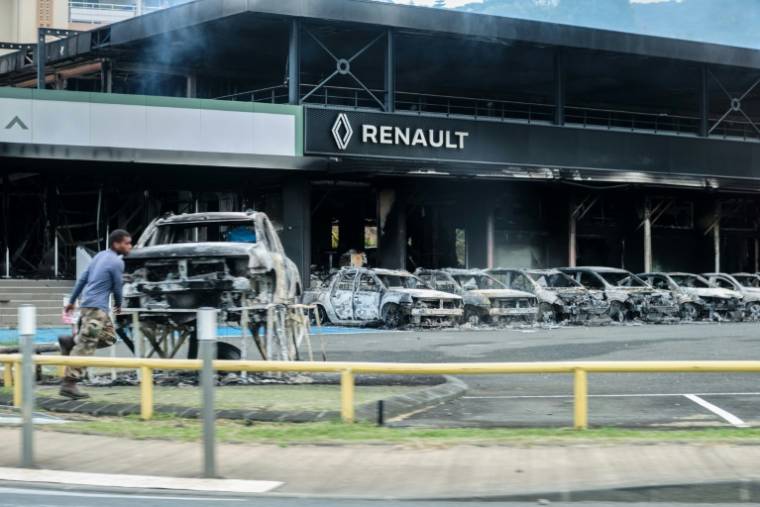 Une concession automobilé incendiée pendant les émeutes à Nouméa, le 14 mai 2024 ( AFP / Theo ROUBY )