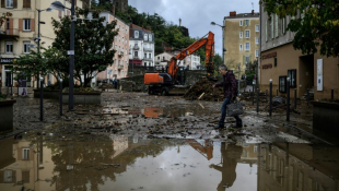 Un habitant marche dans une rue inondée suite à de fortes pluies à Annonay, en Ardèche, le 17 octobre 2024 ( AFP / JEFF PACHOUD )