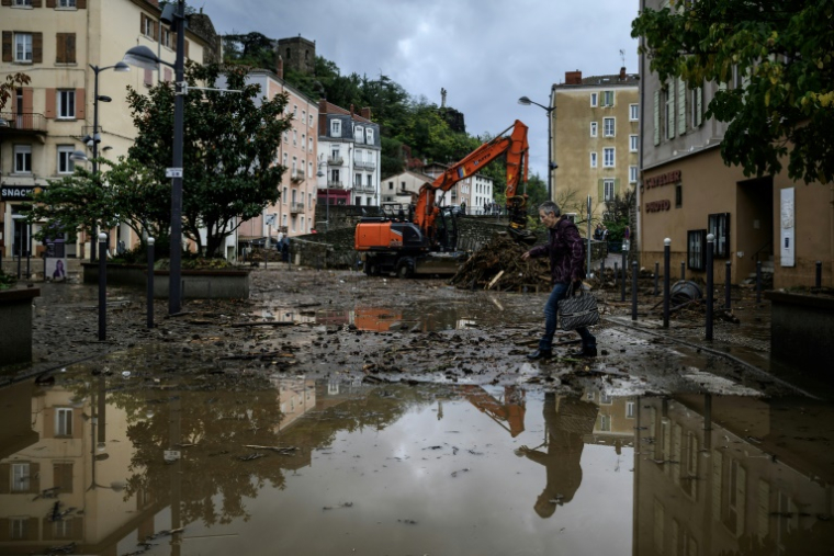 Un habitant traverse une rue inondée d'Annonay, en Ardèche, le 17 octobre 2024 ( AFP / JEFF PACHOUD )