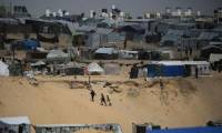 Des Palestiniens marchent dans un camp de personnes déplacées à Rafah, dans le sud de la bande de Gaza, près de la frontière avec l'Egypte, le 28 avril 2024 ( AFP / - )