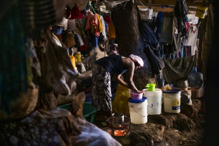 Une femme nettoie des ustensiles de cuisine dans une église transformée en camp pour déplacés internes, dans le quartier de Delmas, à Port-Au-Prince, le 11 juin 2024 en Haïti ( AFP / ROBERTO SCHMIDT )