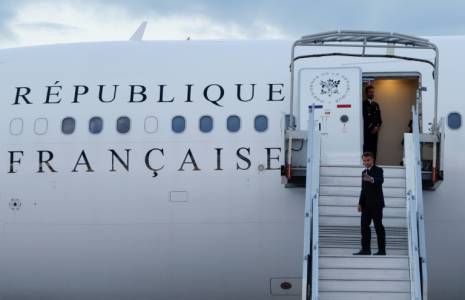 Le président français Emmanuel Macron fait un signe de la main en embarquant dans son avion présidentiel pour se rendre en Nouvelle-Calédonie, à l'aéroport d'Orly, en banlieue de Paris, le 21 mai 2024 ( POOL / Ludovic MARIN )