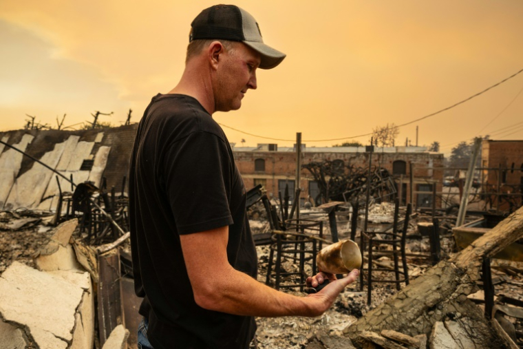 Un homme devant les ruines de son commerce situé à Altadena, près de Los Angeles, ravagé par les incendies, le 9 janvier 2025 ( AFP / Zoë Meyers )