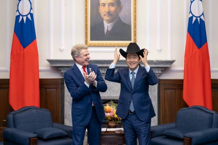 Photo fournie par la présidence taïwanaise montrant le président Lai Ching-te (D) se coiffant d'un chapeau offert par le représentant américain Michael McCaul (G), au palais présidentiel à Taipei le 27 mai 2024 ( TAIWAN PRESIDENTIAL OFFICE / Handout )