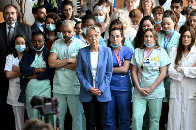 La Première ministre Elisabeth Borne (c) et le ministre de la Santé Francois Braun (g) observent le 24 mai 2023 à l'hôpital européen Georges-Pompidou à Paris une minute de silence en hommage à l'infirmière tuée à Reims ( AFP / bERTRAND GUAY )