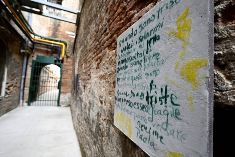 Des poèmes et messages de détenues sur une plaque de lave émaillée de l'artiste libanaise Simone Fattal à la prison pour femmes de la Giudecca accueillant le pavillon du Vatican, lors de la pré-ouverture de la 60e exposition d'art de la Biennale de Venise, le 18 avril 2024 ( AFP / GABRIEL BOUYS )