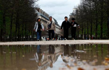 Des touristes se promènent dans le jardin des Tuileries à Paris