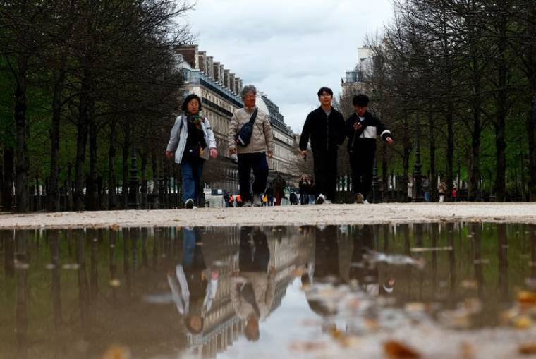Des touristes se promènent dans le jardin des Tuileries à Paris