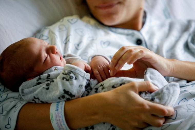 Un nouveau-né dans les bras de sa mère, à Rome