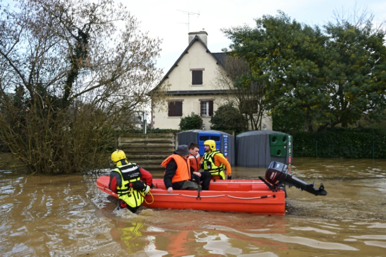 Des pompiers évacuent des habitants à Guipry-Messac (Ille-et-Vilaine), le 27 janvier 2025 ( AFP / DAMIEN MEYER )