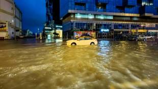 Un taxi traverse une rue inondée après des fortes pluies à Dubaï, le 17 avril 2024 ( AFP / Giuseppe CACACE )