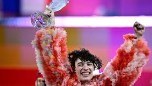 Nemo brandit son trophée après sa victoire à l'Eurovision, le 12 mai 2024 à Malmö, en Suède ( AFP / Tobias SCHWARZ )