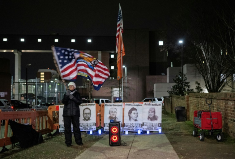 Une femme agite un drapeau en soutien aux assaillants du Capitole, devant la prison de Washington où nombre d'entre eux sont emprisonnés, le 3 janvier 2024 ( AFP / ANDREW CABALLERO-REYNOLDS )