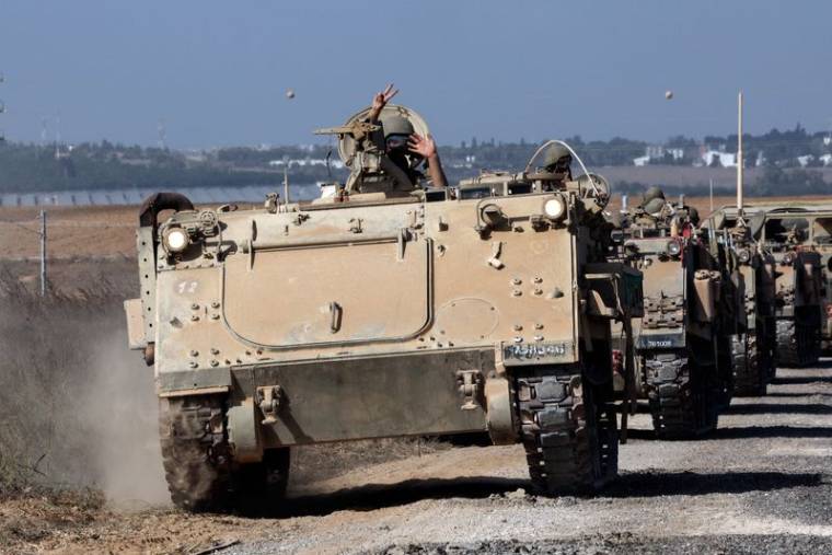 Un convoi de véhicules blindés de transport de troupes prend position près de la frontière entre Israël et la bande de Gaza