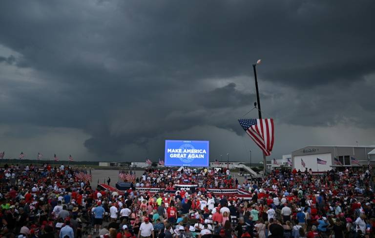 Des partisans de l'ancien président américain Donald Trump attendent son discours  sous un ciel menaçant, peu avant le report de son meeting, à Wilmington, en Caroline du Nord, le 20 avril 2024 ( AFP / Jim WATSON )