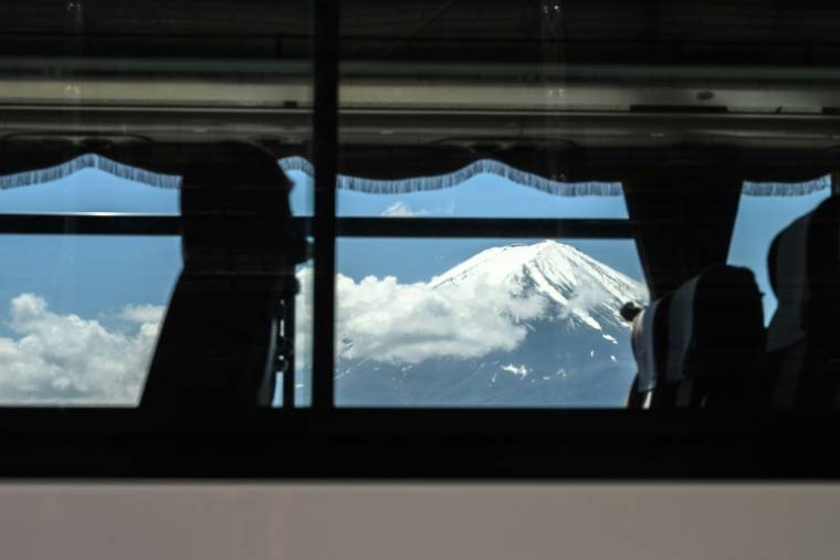 Le mont Fuji vu à travers la vitre d'un bus circulant dans la ville de Fujikawaguchiko, le 3 mai 2024 au Japon ( AFP / Philip FONG )
