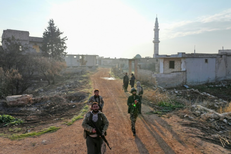 Des combattants rebelles entrent dans le village de Talhiyah, près d'Idleb, dans le nord-ouest de la Syrie, le 29 novembre 2024  ( AFP / Omar HAJ KADOUR )