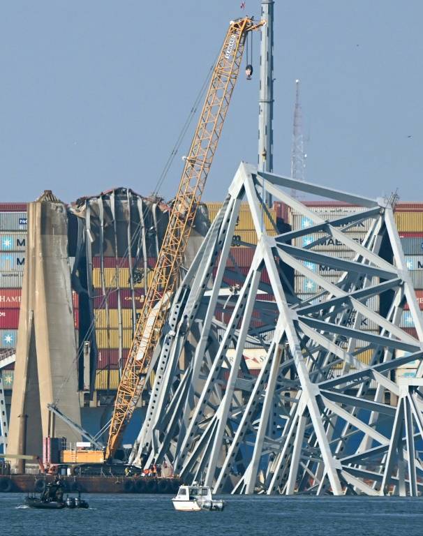 Une grue commence le nettoyage des débris du pont de Baltimore percuté par un cargo, le 29 mars 2024 ( AFP / Mandel NGAN )