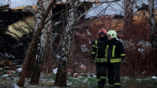 Des pompiers lituaniens travaillent à côté de l'épave d'un avion cargo qui s'est écrasé près de l'aéroport international de Vilnius, le 25 novembre 2024 ( AFP / Petras MALUKAS )