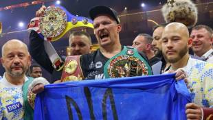 Oleksandr Usyk célèbre avec un drapeau ukrainien sa victoire sur Tyson Fury dans le championnat du monde des lourds à Riyadh, le 19 mai 2024. ( AFP / Fayez NURELDINE )