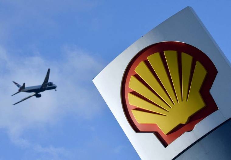 Un avion de ligne survole le logo Shell dans une station-service de l'ouest de Londres