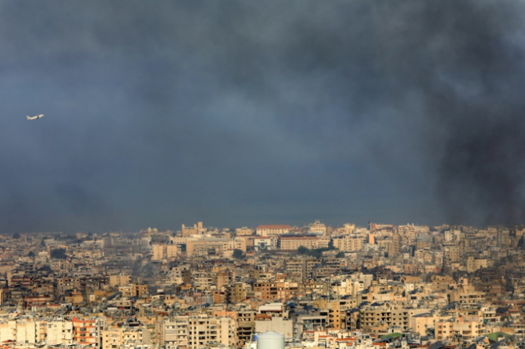 Un avion de la Middle East Airlines est vu décollant de l'aéroport international de Beyrouth au milieu de la fumée s'élevant au-dessus de la banlieue sud de la capitale libanaise, après des frappes israéliennes, le 28 septembre 2024 ( AFP / - )