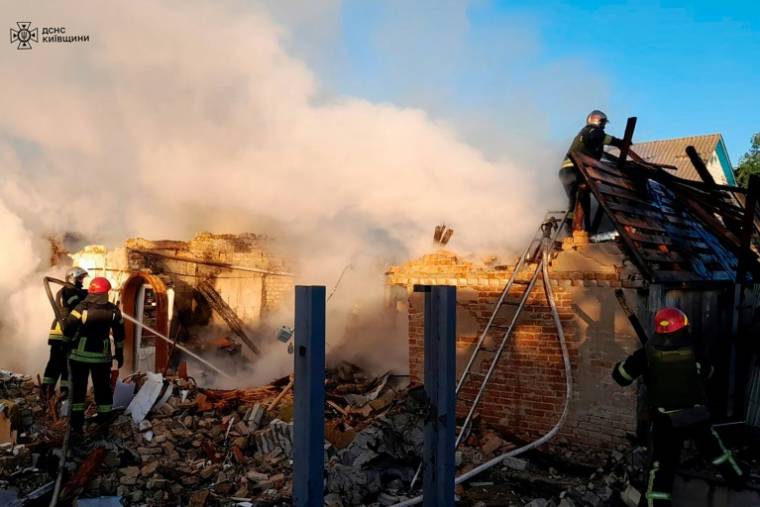 Photo diffusée par les services d'urgence ukrainiens, le 8 mai 2024, montrant des secours intervenant sur une maison détruite par une attaque de missile dans la région de Kiev ( Services d'urgence ukrainiens / Handout )