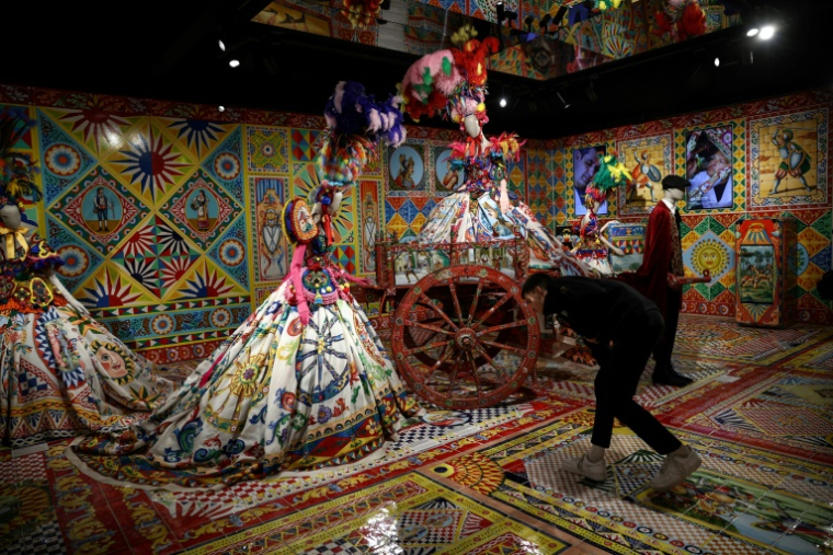 Une visiteuse regarde l'une des créations de la maison de couture italienne Dolce&Gabbana à l'exposition "Du coeur à la main" au Grand Palais à Paris, le 9 janvier 2025 ( AFP / Anne-Christine POUJOULAT )