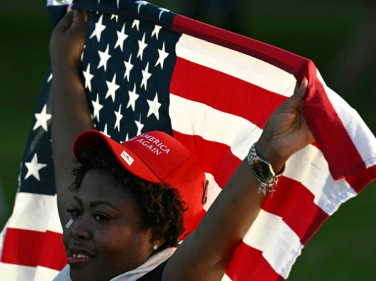 Une partisane de Donald Trump brandit un drapeau américain lors du meeting du candidat républicain à la présidentielle américaine dans le Bronx, à New York, le 23 mai 2024 ( AFP / Jim WATSON )