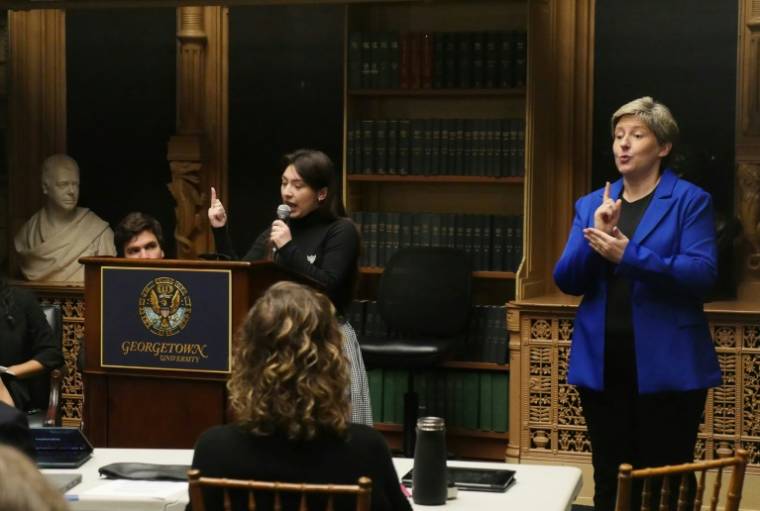 Un interprète en langue des signes (D) lors d'un débat entre étudiants à Washington, aux Etats-Unis, le 11 avril 2024 ( AFP / Amel SEMMACHE )