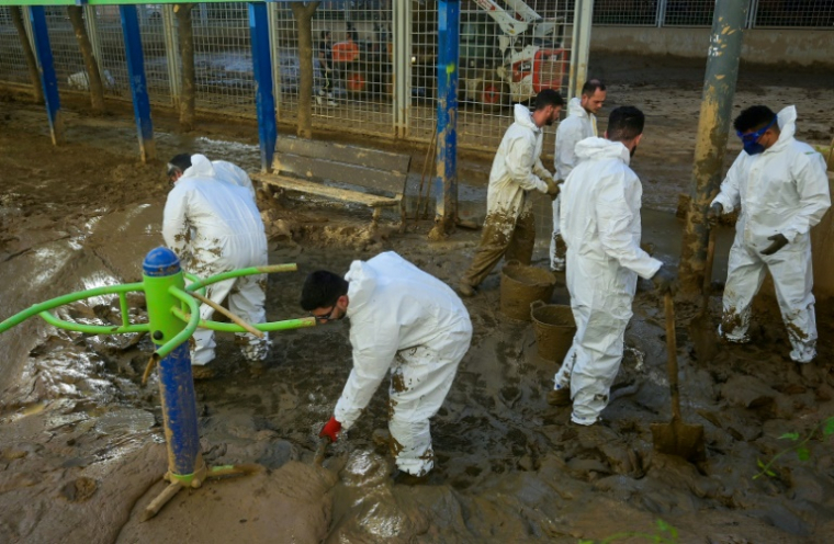 Des soldats nettoient une aire de jeu dévastée par les inondations, à Paiporta près de Valence, le 27 novembre 2024 ( AFP / JOSE JORDAN )