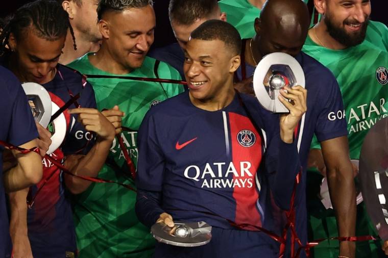 L'attaquant star du PSG Kylian Mbappé avec le trophée de champion de France lors des célébrations d'après-match contre Toulouse, le 12 mai 2024 au Parc des Princes      ( AFP / FRANCK FIFE )