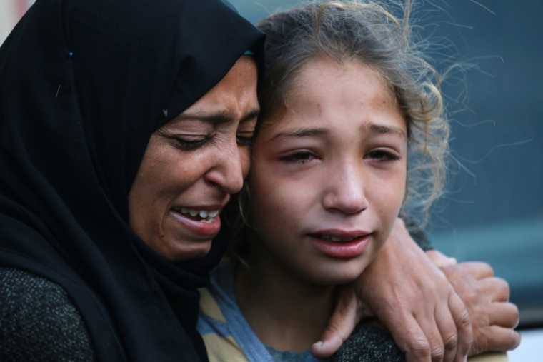 Une femme et une fillette  palestiniennes pleurent devant l'hôpital des martyrs d'al-Aqsa à Deir el-Balah, dans le centre de la bande de Gaza, où ont été transférées les victimes d'une frappe israélienne contre Nousseirat, le 21 novembre 2024 ( AFP / Bashar TALEB )