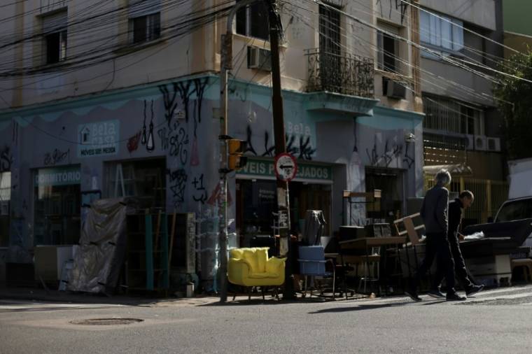 Des vendeurs font sécher leurs marchandises  après les inondations qui ont touché leurs magasins à Porto Alegre, dans l'État du Rio Grande do Sul, au Brésil, le 14 mai 2024 ( AFP / Anselmo Cunha )