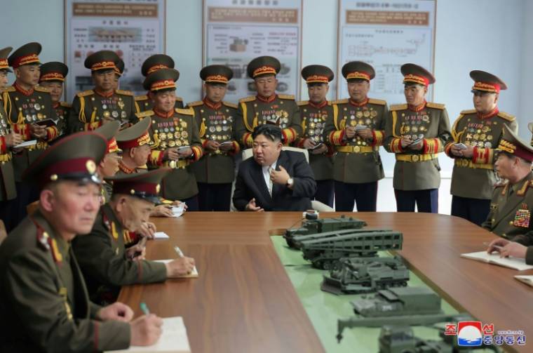 Photo diffusée le 26 avril 2024 par l'agence nord-coréenne Kcna du dirigeant nord-coréen Kim Jong Un (c) en visite à l'Université militaire Kim Il Sung à Pyongyang, le 25 avril 2024 ( KCNA VIA KNS / STR )