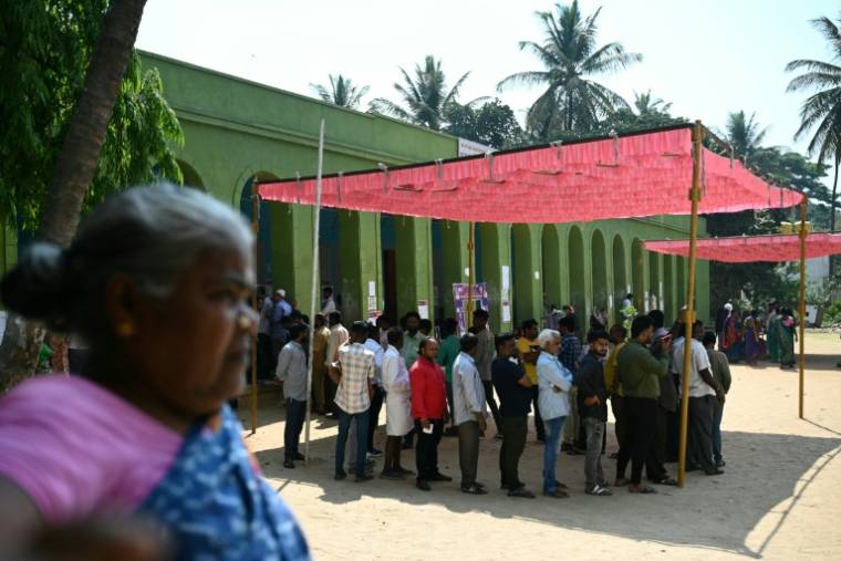 Des électeurs, à l'abri du soleil sous un auvent, attendent pour voter, le 26 avril 2024 à Bangalore, en Inde ( AFP / Idrees MOHAMMED )