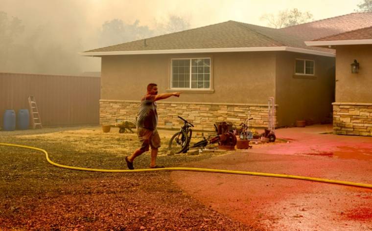 Un habitant tente de protéger sa maison d'un incendie à Oroville, le 3 juillet 2024 en Californie ( AFP / JOSH EDELSON )