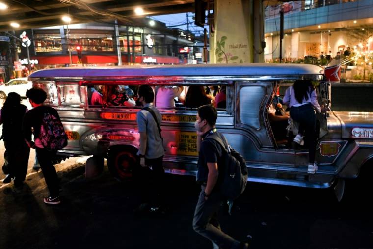 Des passagers attendent des jeepneys, taxis collectifs sur des châssis de jeep, dans une rue de Manille, le 15 janvier 2024 ( AFP / JAM STA ROSA )