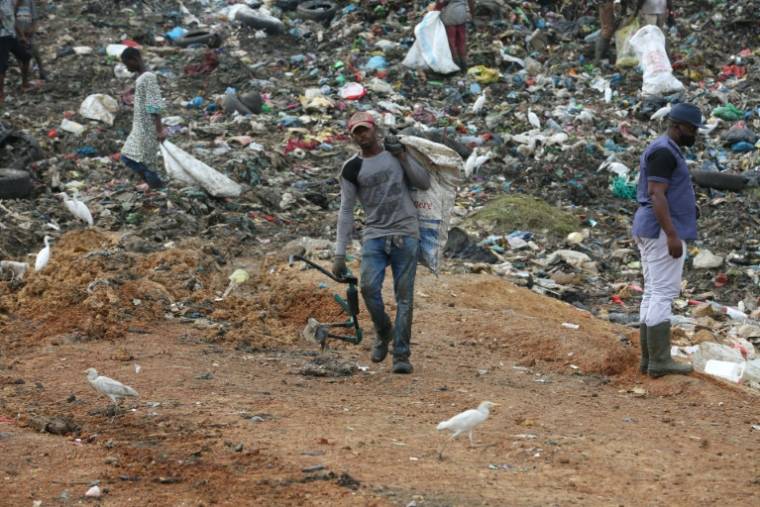 Des personnes cherchent des détritus à recycler dans une décharge à ciel ouvert à Libreville, le 18 juin 2021 ( AFP / Steeve Jordan )